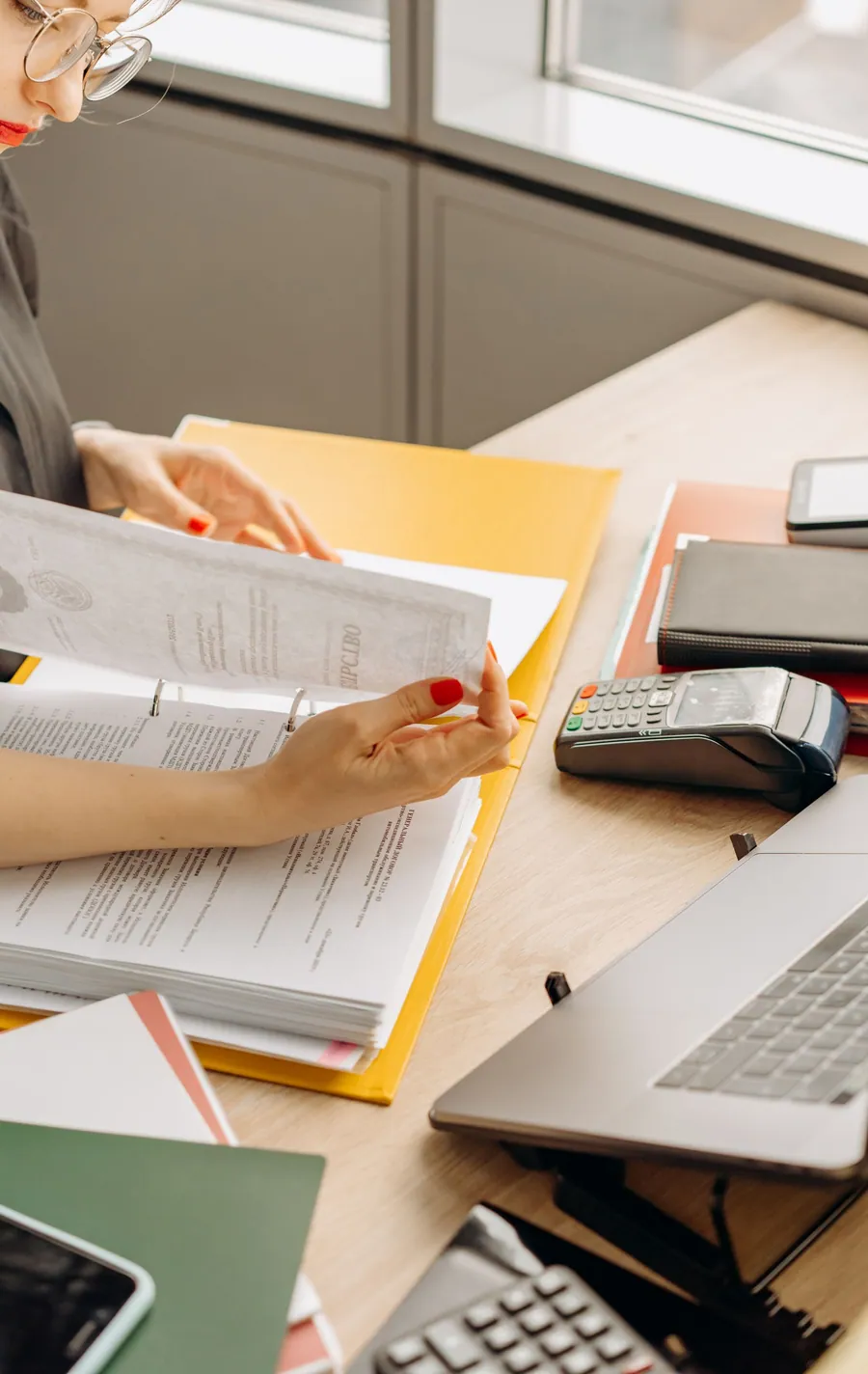 Profissional analisando documentos financeiros em uma mesa de trabalho